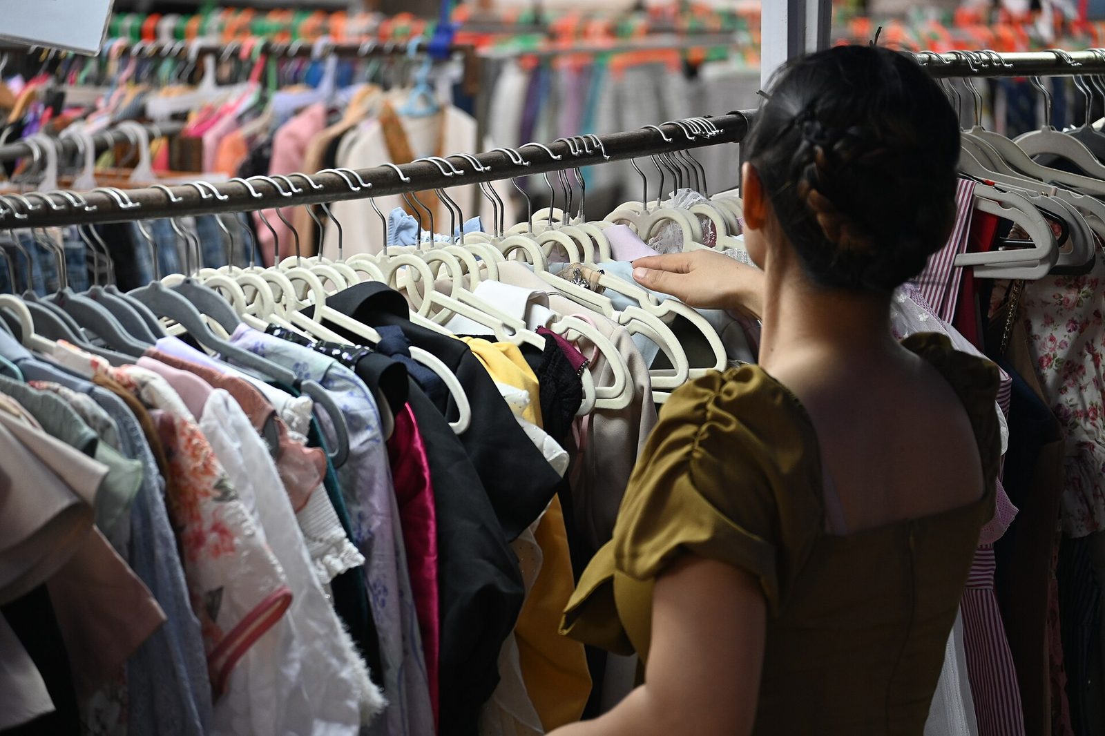 Rack of donated formal dance dresses in a range of colors