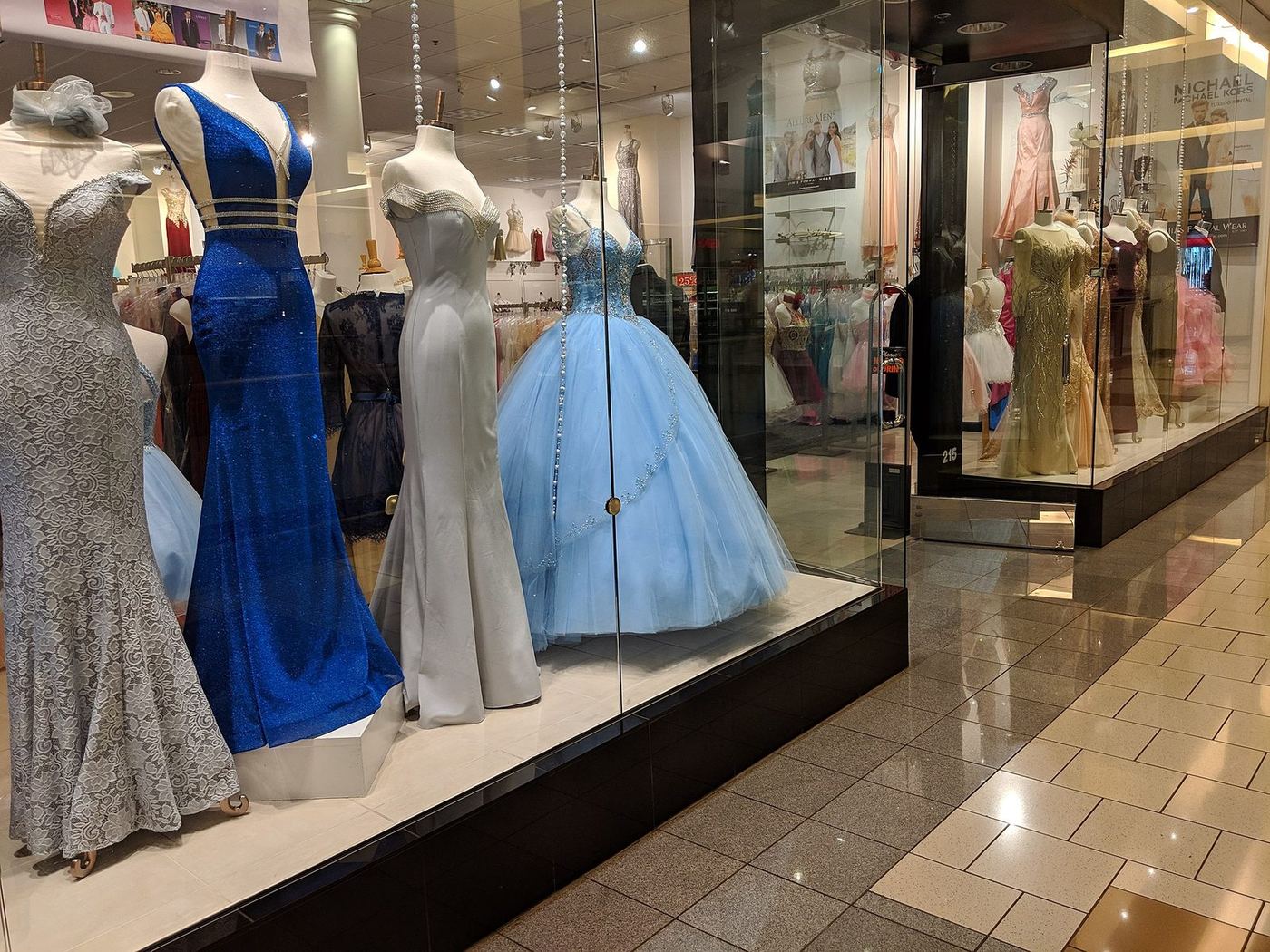 Window display of a prom dress boutique with gowns on mannequins